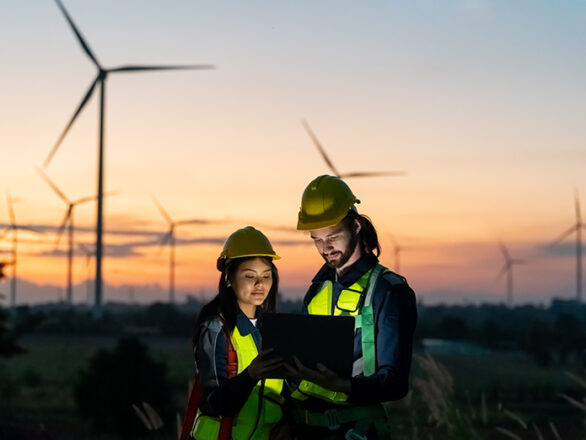 Workers inspecting wind turbines