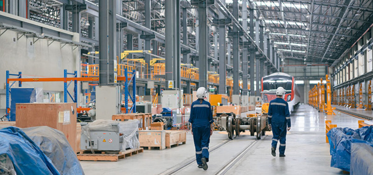 Workers inspection railway lines and trains in workshop